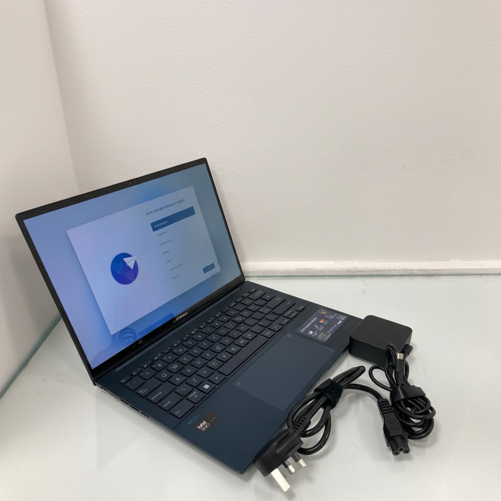 Laptop with charger and cables on a white surface